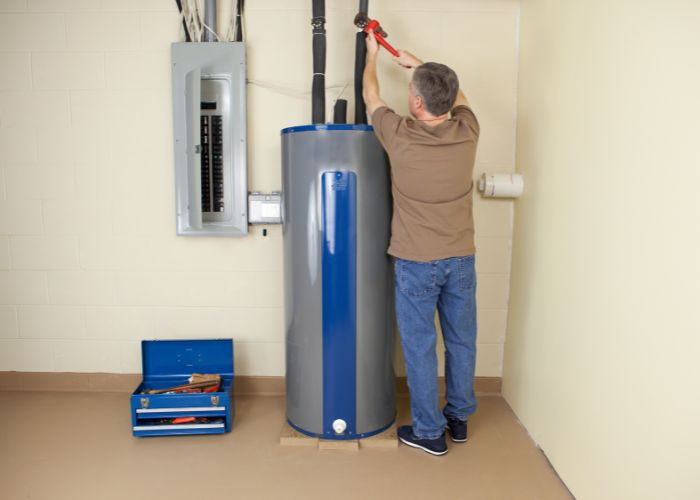 Plumber replacing a water heater in a garage in Massachusetts