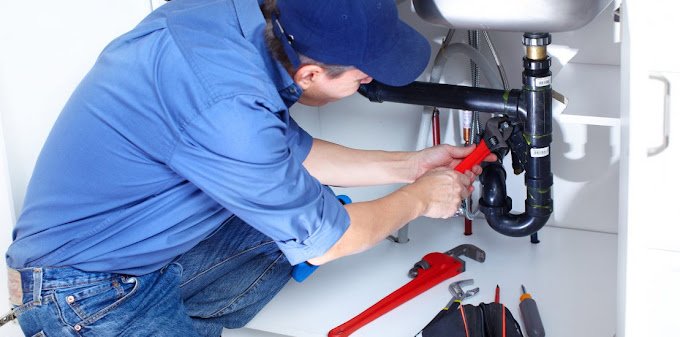 A plumber working under a sink.